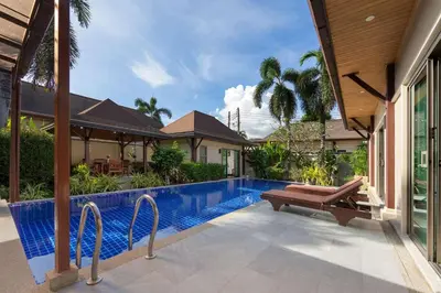 a swimming pool with a bench next to a house at Villa Adonara Private Pool Escape Near Nai Harn in Nai Harn Beach
