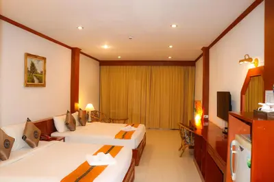 a hotel room with two beds and a television at Andaman Seaside Resort Bangtao Beach in Bang Tao Beach