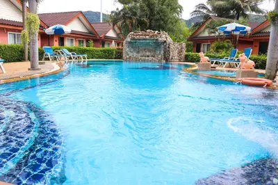 a large swimming pool with a water fountain at Andaman Seaside Resort Bangtao Beach in Bang Tao Beach