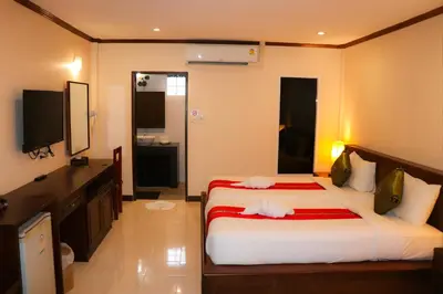 a bedroom with two beds and a flat screen tv at Andaman Seaside Resort Bangtao Beach in Bang Tao Beach