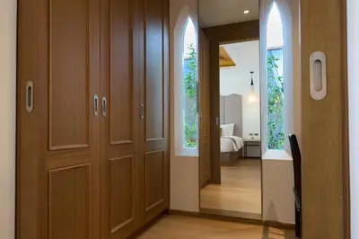 a hallway with wooden doors and a bedroom at Malisa Villa Suites - SHA Extra Plus in Kata Beach