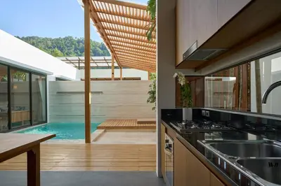 a kitchen with a swimming pool in the background at Malisa Villa Suites - SHA Extra Plus in Kata Beach
