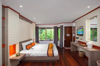 a bedroom with a large bed and a television at Phi Phi Natural Resort in Phi Phi Don