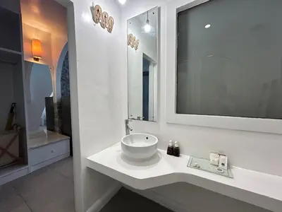 a white bathroom with a sink and a mirror at Benyada Lodge - Surin Beach in Surin Beach