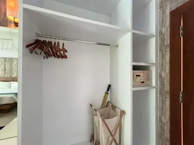 a room with white walls and a closet with hangers at Benyada Lodge - Surin Beach in Surin Beach