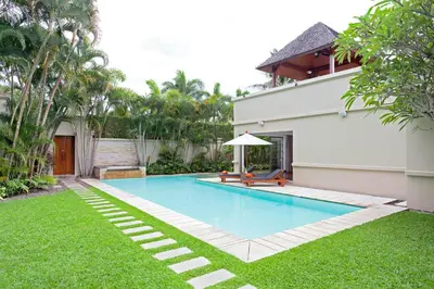 a swimming pool in a yard next to a house at The Residence Resort in Bang Tao Beach