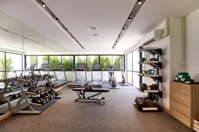 a gym with lots of treadmills and machines at OUTRIGGER Surin Beach Resort in Surin Beach