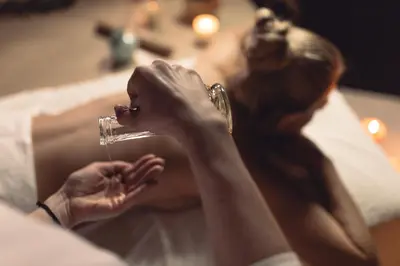 a woman laying on a bed drinking from a glass at Aleenta Phuket - Phang Nga - The Leading Hotels of the World in Natai Beach