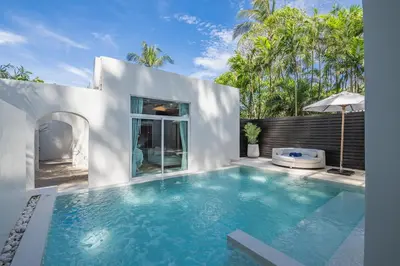 a swimming pool in front of a white house at Aleenta Phuket - Phang Nga - The Leading Hotels of the World in Natai Beach