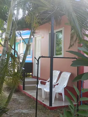 a house with two white chairs and a porch at Chill land house in Bang Tao Beach