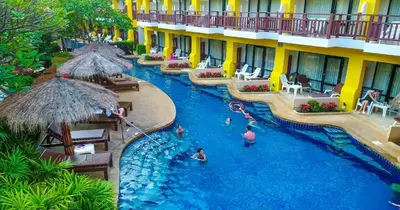 a pool at a resort with people in it at Woraburi Phuket Resort & Spa - SHA Plus in Karon Beach