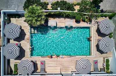 an overhead view of a swimming pool with umbrellas at BYD Lofts - Boutique Hotel & Serviced Apartments - Patong Beach, Phuket in Patong Beach
