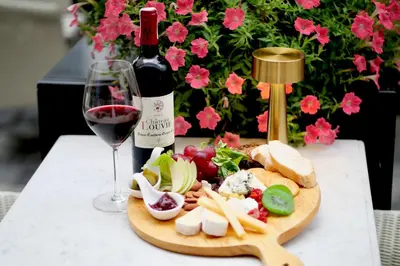 a bottle of wine and a plate of food and a wine glass at BYD Lofts - Boutique Hotel & Serviced Apartments - Patong Beach, Phuket in Patong Beach