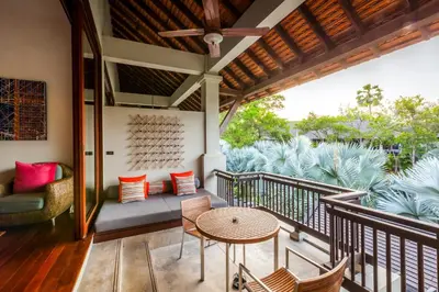 a balcony with a table and chairs and a couch at The Slate, Phuket in Nai Yang Beach