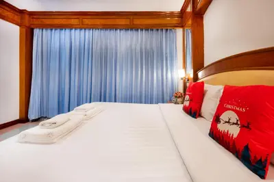 a bedroom with a white bed with red pillows at Lamai Hotel in Patong Beach
