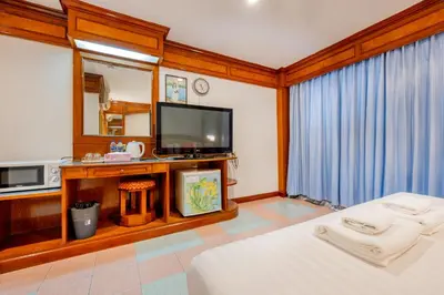 a bedroom with a bed and a tv and a mirror at Lamai Hotel in Patong Beach