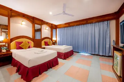 a hotel room with two beds and a tv at Lamai Hotel in Patong Beach