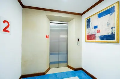 an elevator in a building with a painting on the wall at Lamai Hotel in Patong Beach