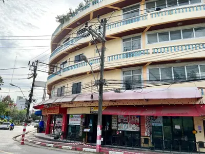 a building on a street corner with a building at Lamai Apartment in Patong Beach