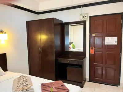 a bedroom with a bed and a cabinet and a mirror at Lamai Apartment in Patong Beach