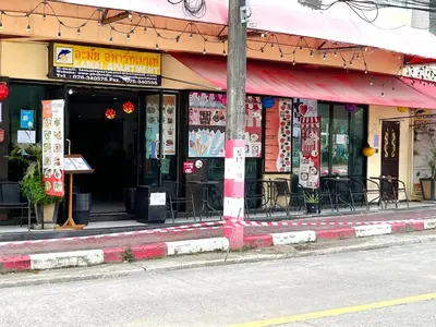 a restaurant with signs on the side of a street at Lamai Apartment in Patong Beach