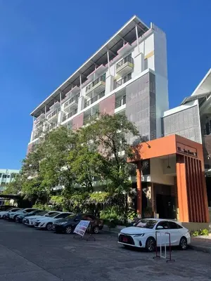 a parking lot with cars parked in front of a building at Twin Hotel in Phuket Town
