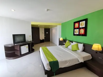 a bedroom with a large bed with a green wall at Twin Hotel in Phuket Town