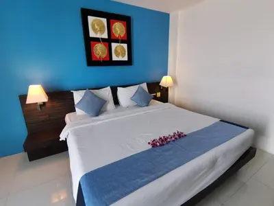 a bedroom with a large white bed with blue walls at Twin Hotel in Phuket Town