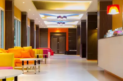 a lobby with colorful chairs and tables at Twin Hotel in Phuket Town