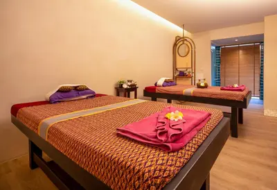 a bedroom with two beds with towels and a mirror at Deevana Plaza Phuket - SHA Extra Plus in Patong Beach