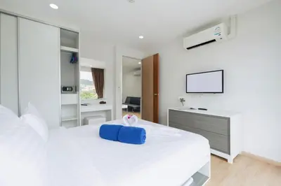 a white bedroom with a blue box on a bed at Ozone Condotel by RESAVA in Kata Beach