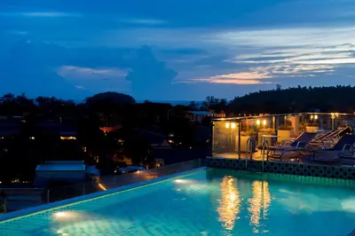 a swimming pool at night with a house at Ozone Condotel by RESAVA in Kata Beach