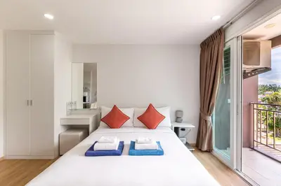 a bedroom with a large white bed with two pillows at Ozone Condotel by RESAVA in Kata Beach