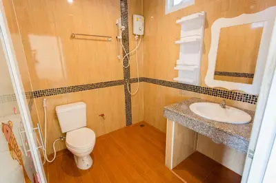 a bathroom with a toilet and a sink at Surin Sunset Hotel - SHA in Surin Beach