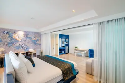 a bedroom with a large bed and a dining room at Bhukitta Boutique Hotel Phuket Town in Phuket Town