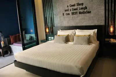 a bedroom with a large bed with white sheets and pillows at The House Patong in Patong Beach