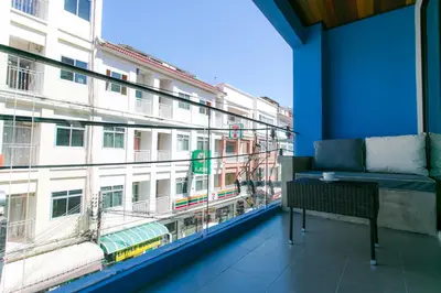 a balcony with a couch and a large window at The House Patong in Patong Beach