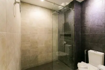 a bathroom with a glass shower with a toilet at The House Patong in Patong Beach