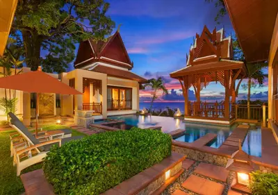 a villa with a swimming pool in front of a house at Diamond Cliff Resort & Spa, Patong Beach in Patong Beach