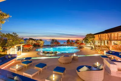 an outdoor patio with a swimming pool and lounge chairs at Diamond Cliff Resort & Spa, Patong Beach in Patong Beach