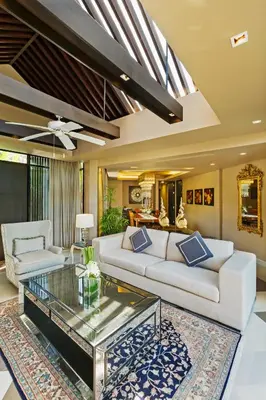 a living room with a white couch and a glass coffee table at Impiana Beachfront Resort Patong, Phuket in Patong Beach