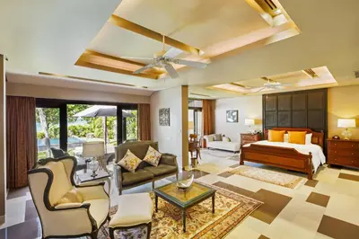 a living room with a bed and a couch at Impiana Beachfront Resort Patong, Phuket in Patong Beach