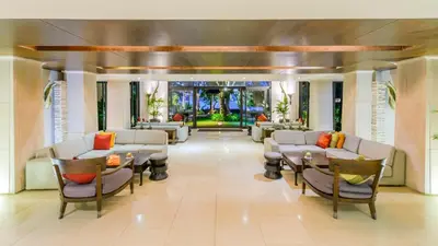 a lobby of a hotel with chairs and tables at Impiana Beachfront Resort Patong, Phuket in Patong Beach