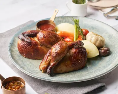 a plate of food with chickens and vegetables on a table at M Social Hotel Phuket in Patong Beach