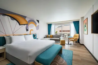 a hotel room with a bed and a living room at M Social Hotel Phuket in Patong Beach
