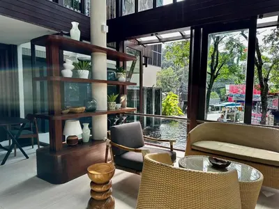 a room with chairs and a table and windows at Pakasai Resort in Ao Nang Beach