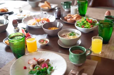 a table with plates of food and cups of orange juice at Pakasai Resort in Ao Nang Beach