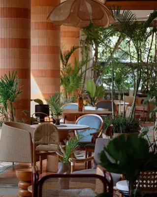 a restaurant with tables and chairs and potted plants at Pakasai Resort in Ao Nang Beach