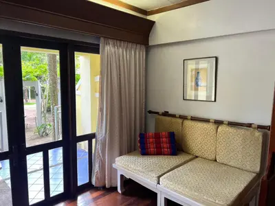 a living room with a couch in front of a window at MW Krabi Beach Resort - Ao Nang - SHA Extra Plus in Ao Nang Beach