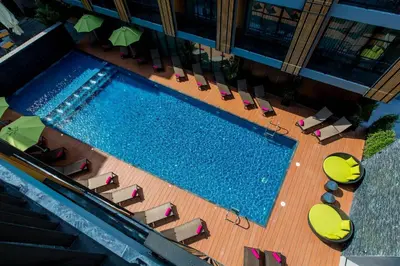 an overhead view of a swimming pool with chairs and umbrellas at GLOW Ao Nang Krabi in Ao Nang Beach